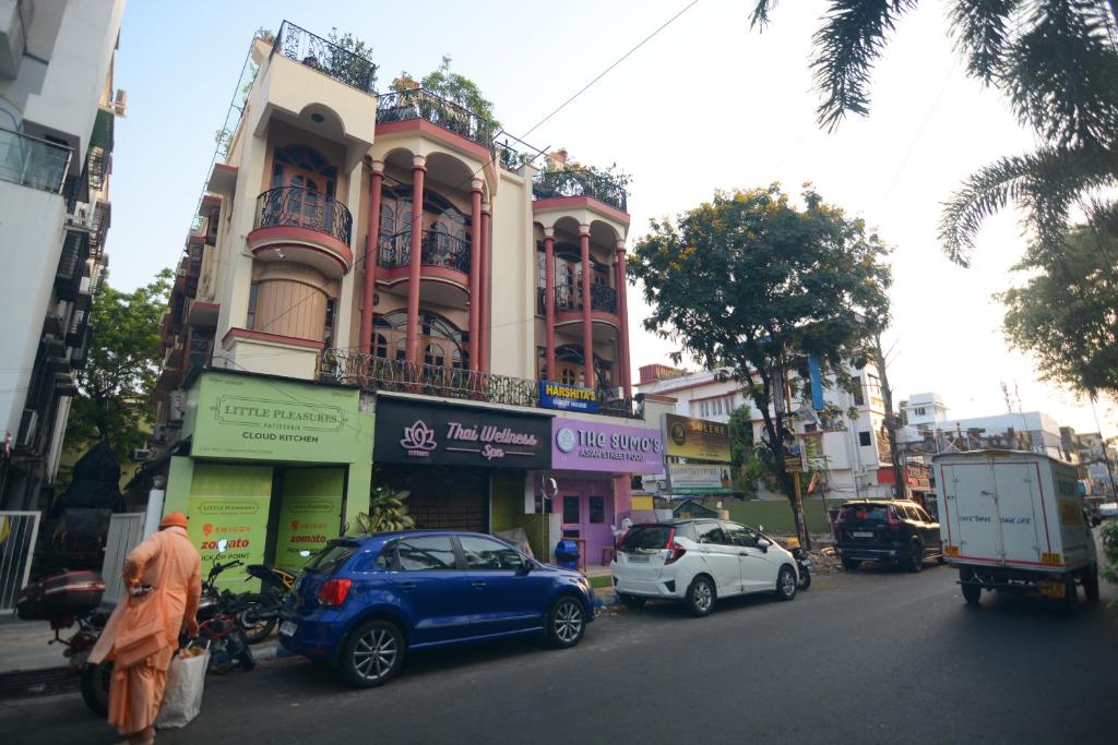a man in an orange robe standing in front of a building at Harshita's Guest House in kolkata