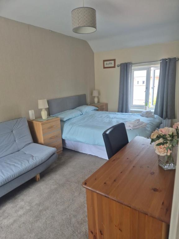 a bedroom with two beds and a table and a couch at ACCOMADATION WREXHAM in Wrexham
