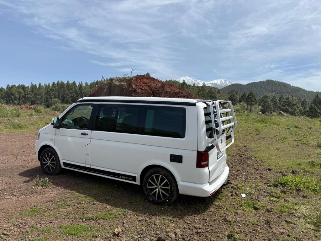 a white van is parked in a field at Nomad Campers VW California in La Mareta