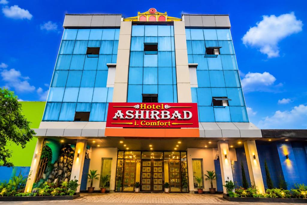 a building with a red sign in front of it at Hotel Ashirbad I comfort Near Railway Station in Bhubaneshwar