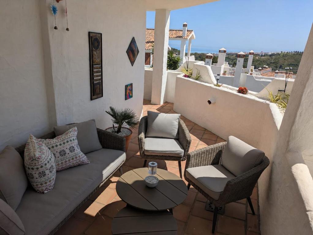 a patio with a couch and chairs and a table at Green Haven Casares in Casares