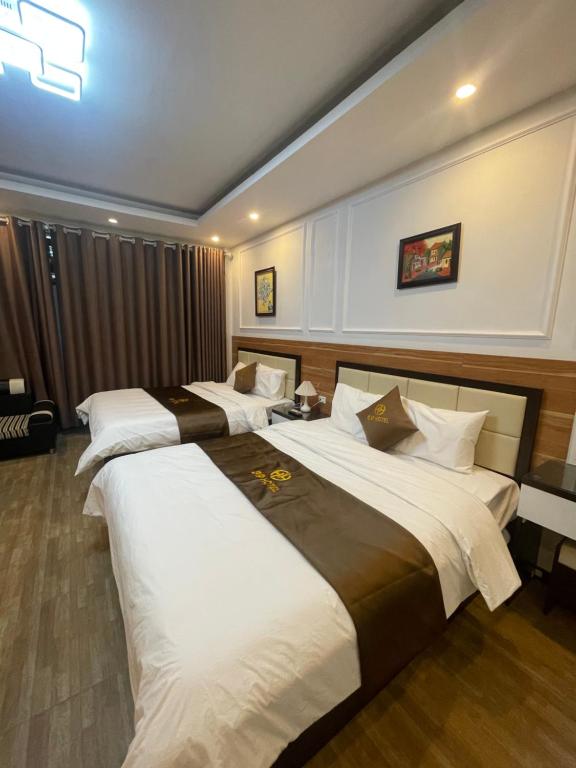 a hotel room with three beds in it at G9 Home hotel in Hanoi