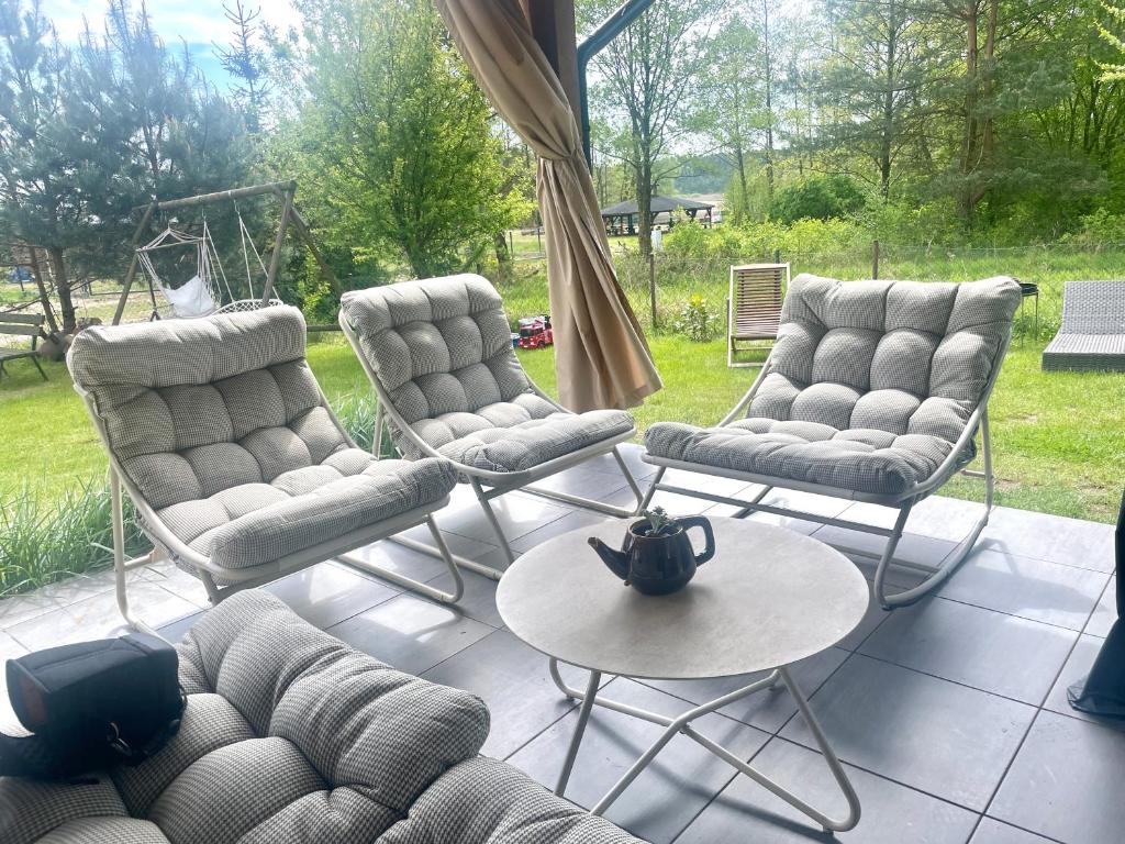 a patio with three chairs and a table and a couch at Malanówka II Radęcin in Radęcin