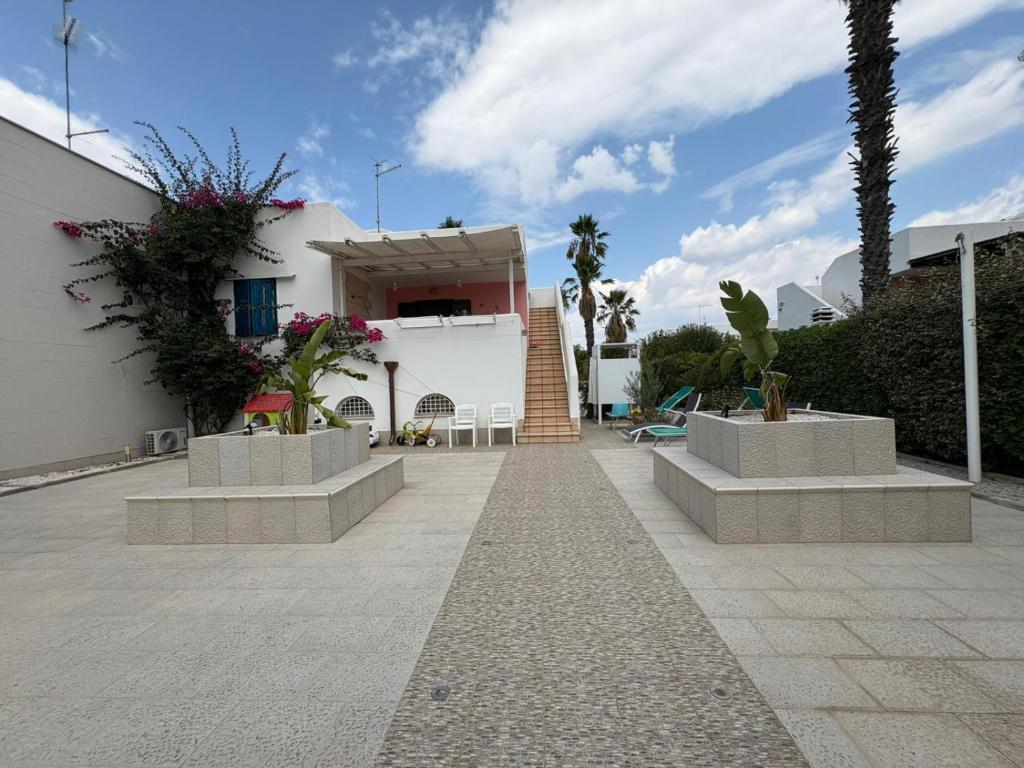 a house with two benches in front of it at Satiria residence ML in Metaponto