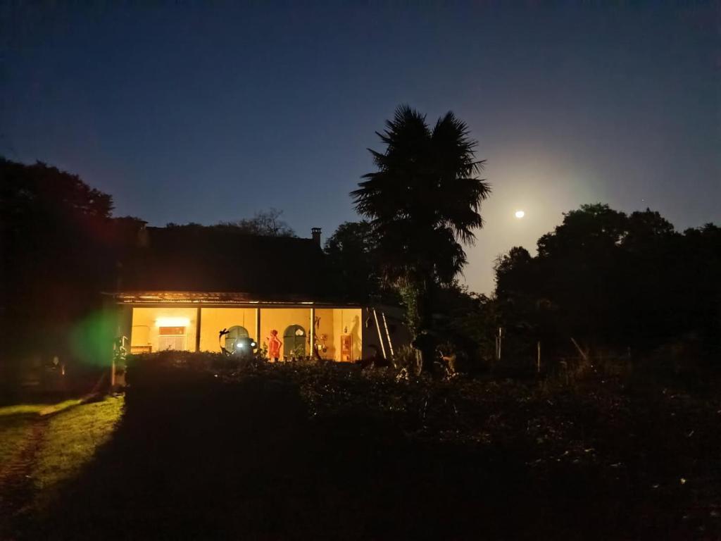 a house at night with the moon behind it at WCB Bees in Saint-Vérain