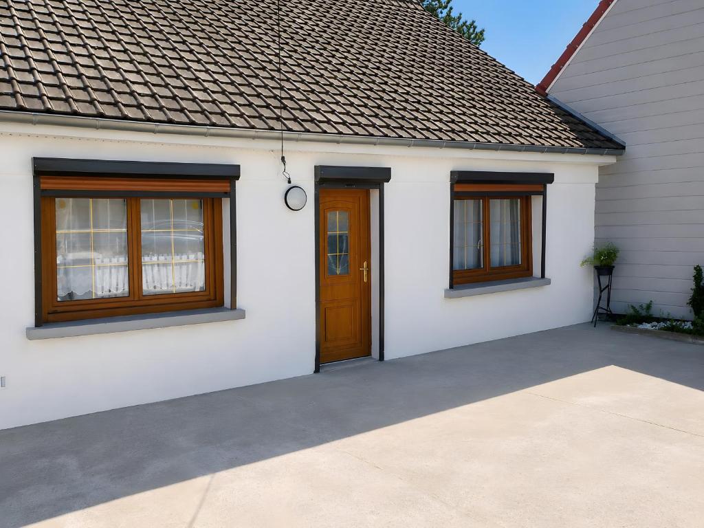 a white house with a brown door and windows at gite 618 in Helfaut