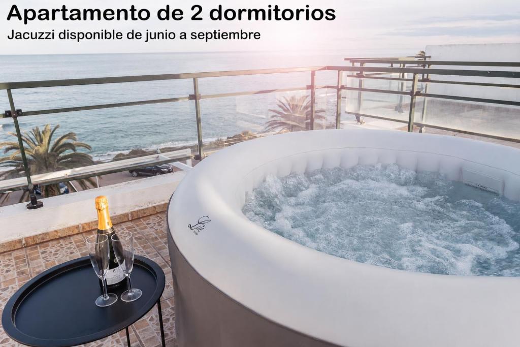 a bath tub with a bottle of champagne on a balcony at La PARRETA PRIMERA LÍNEA in Vinarós