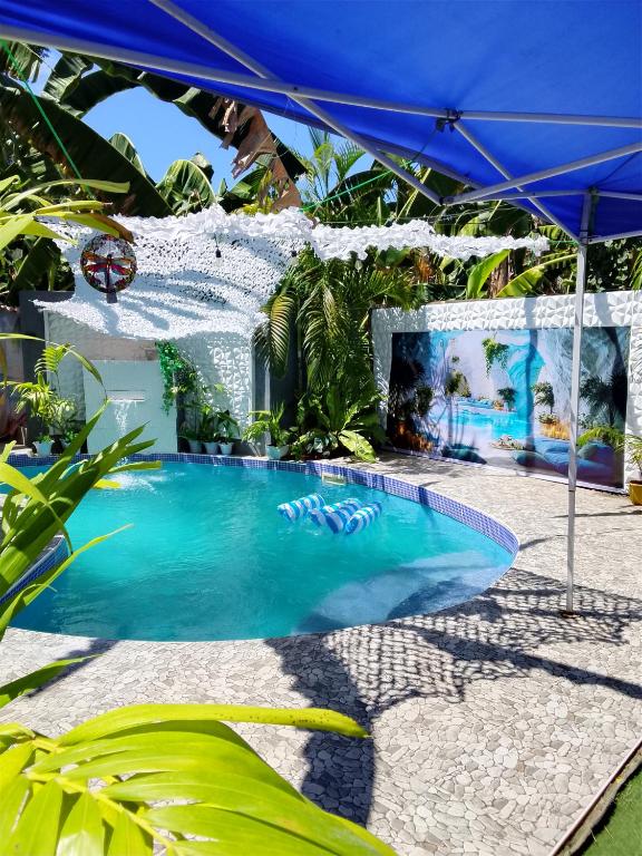 a swimming pool in a resort with a blue umbrella at Two crazy monkeys in Bakjawan