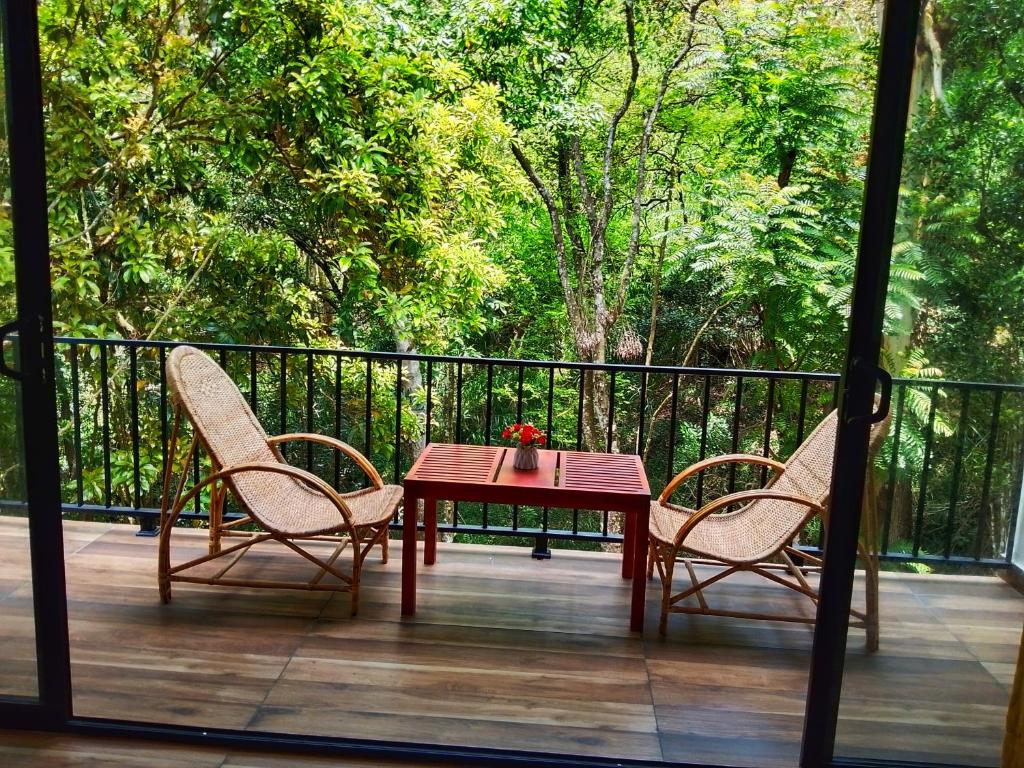 a wooden table and two chairs on a deck at Ella Green Cottages in Ella