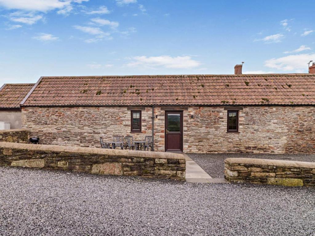 a brick building with a table and chairs in front of it at 2 Bed in Bristol oc-72836 in Chew Magna