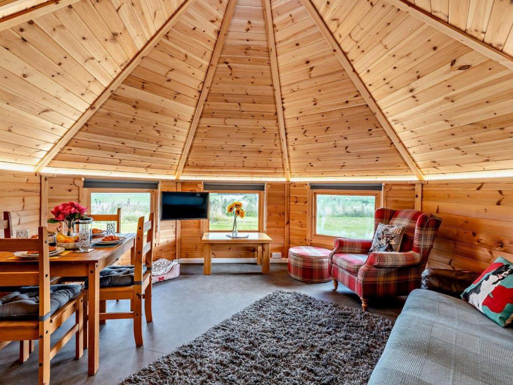 a room with a wooden ceiling with a table and chairs at 1 Bed in Lanark oc-91248 in Libberton