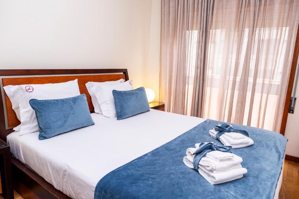 a hotel room with a bed with towels on it at RH Charming Apartment - D Nuno in Barcelos
