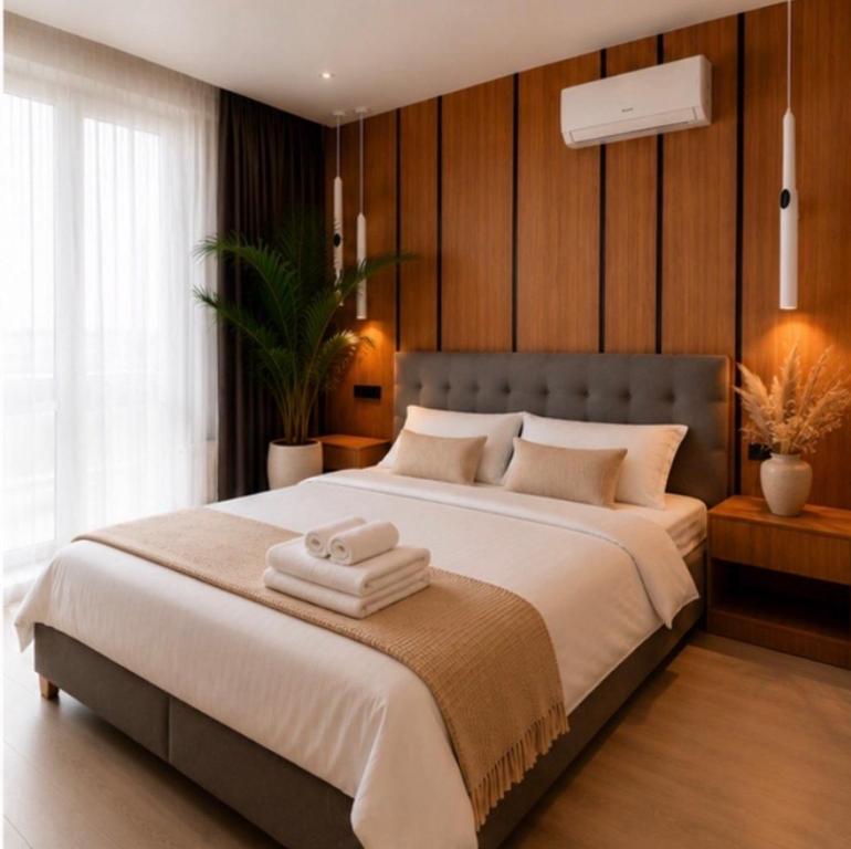 a bedroom with a large bed with two towels on it at Апартаменти VIP in Ternopil