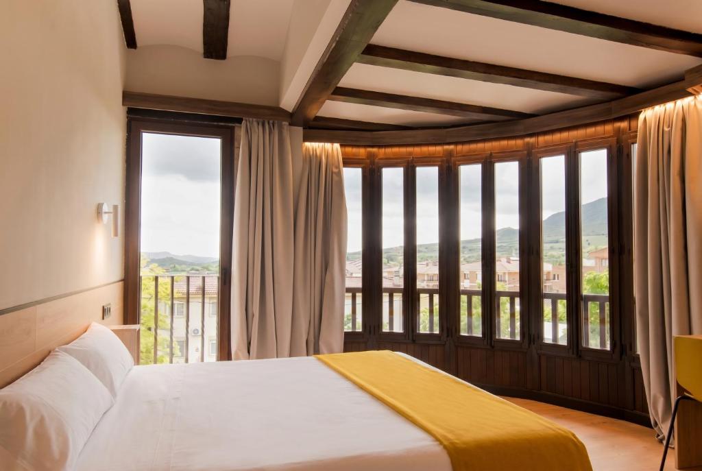 a bedroom with a bed and a large window at Hotel Casa Juan in Ayegui