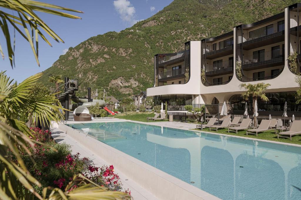 a hotel with a swimming pool in front of a mountain at Amaris Suites Rabland, Südtirol in Rablà