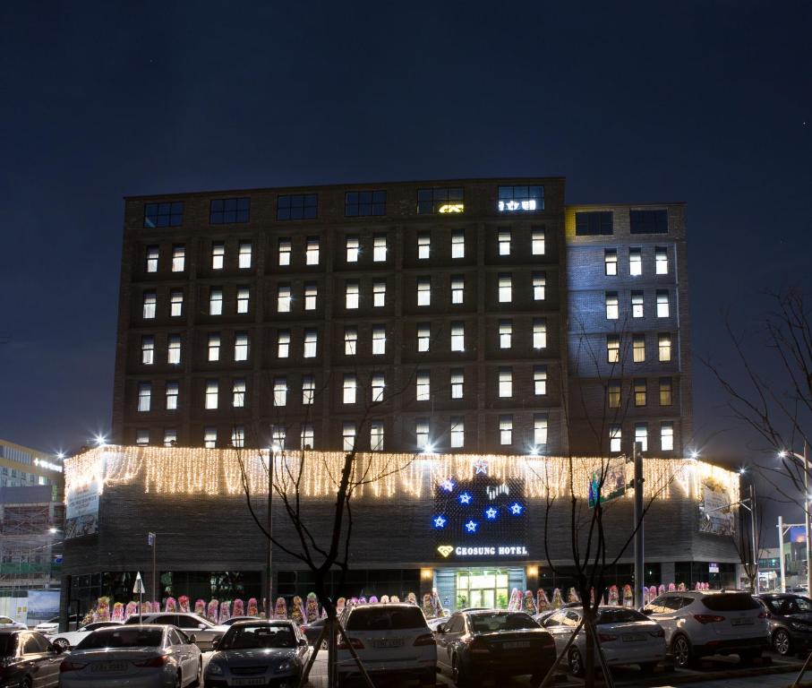 un edificio con coches aparcados delante de él por la noche en Geosung Hotel, en Eumseong