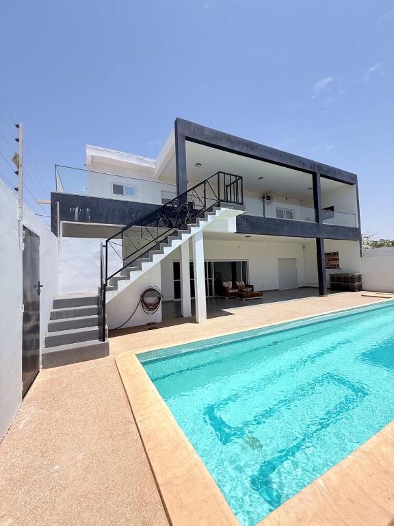 a villa with a swimming pool and a house at Maison villa la faveur in Ngaparou