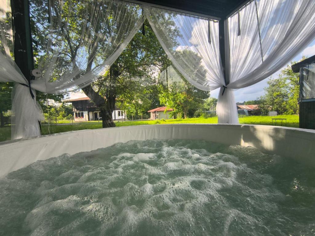 a hot tub with white drapes in a backyard at Vintage House in Elena