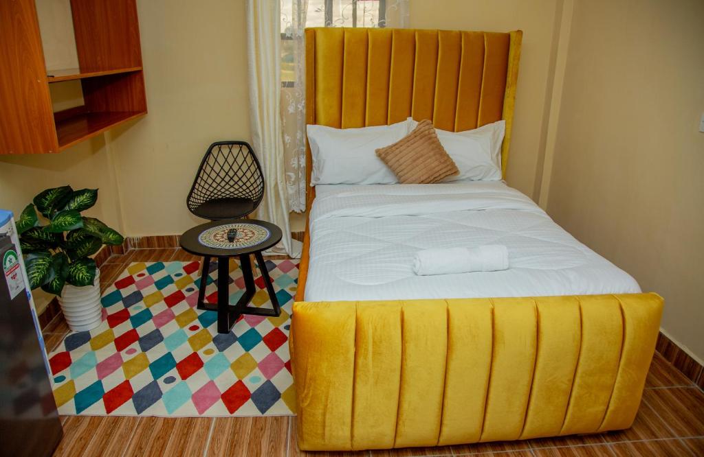 a bedroom with a bed with a yellow foot board at Mustard studio with free WI-FI in Nanyuki
