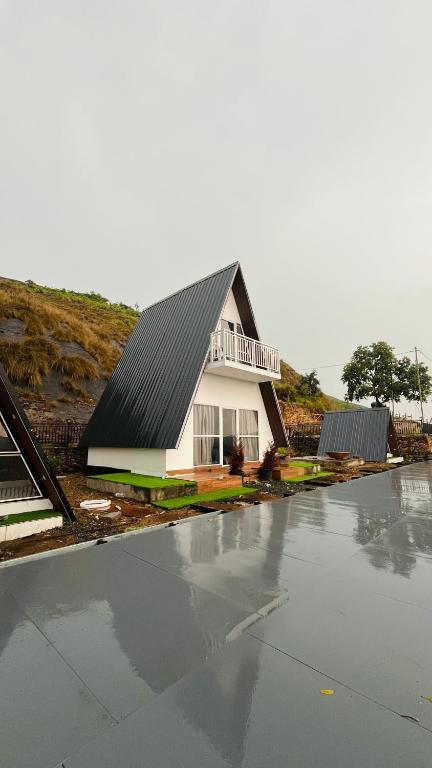 a house with a black roof on top of a parking lot at Varattumedu Hill in Vagamon