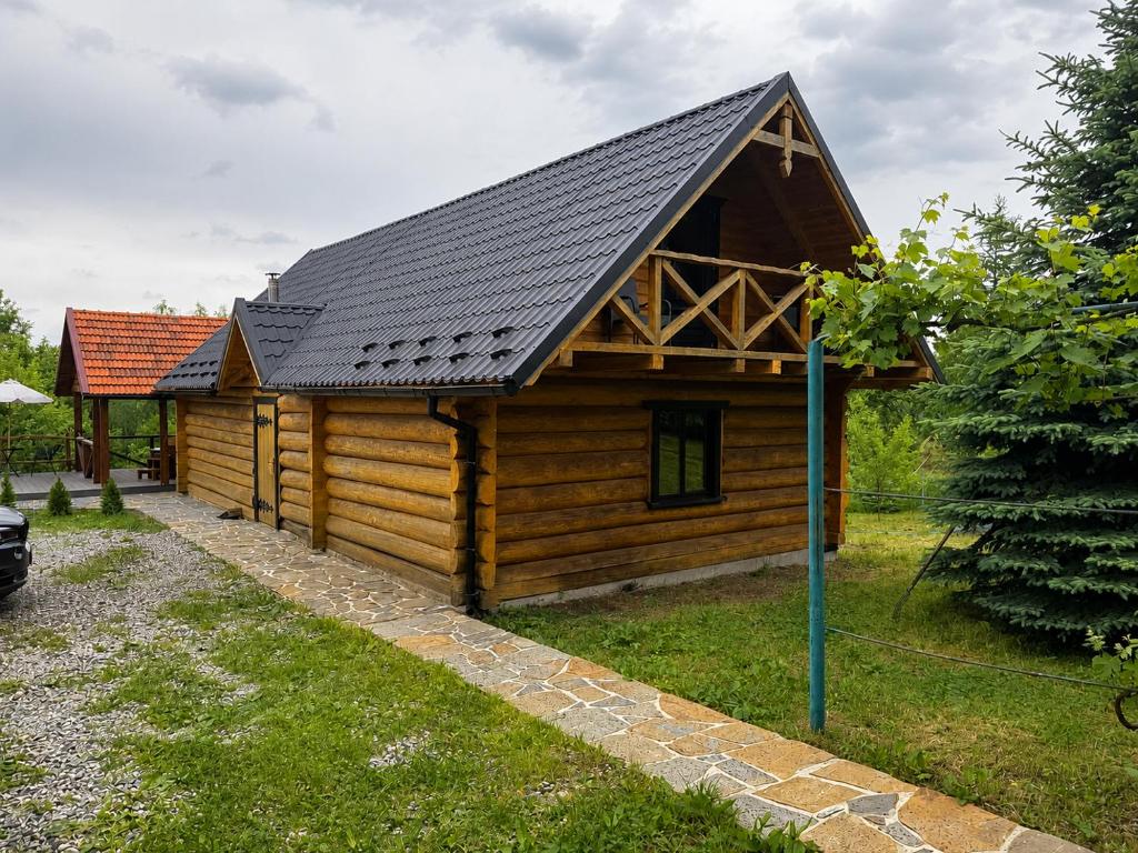 a log cabin with a black roof at Садиба Сенчина in Utoropy