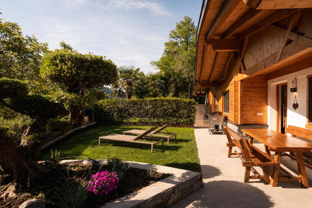 a patio with a table and benches on a yard at Chalet Resort Innerluferhof in Rifiano