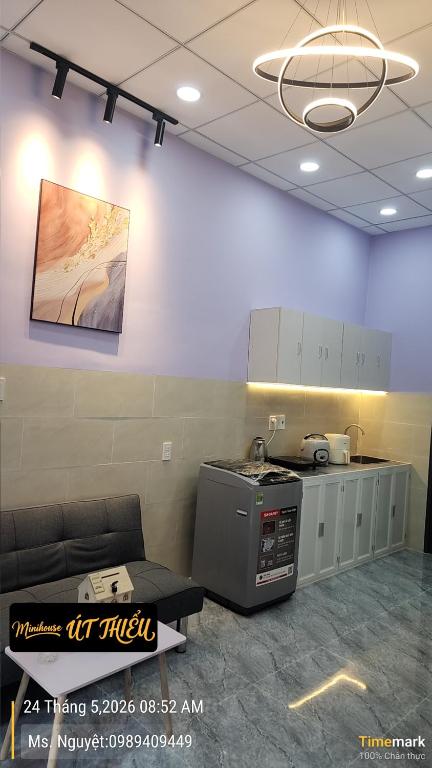 a room with a stove and a couch in a room at Minihouse Út Thiểu in Rạch Giá