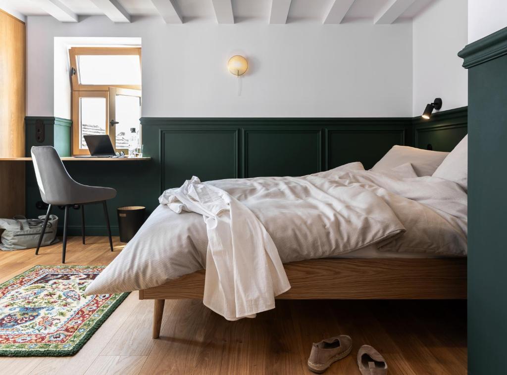 a bedroom with a bed and a desk with a chair at Hotel Bleibe in Freudenberg am Main
