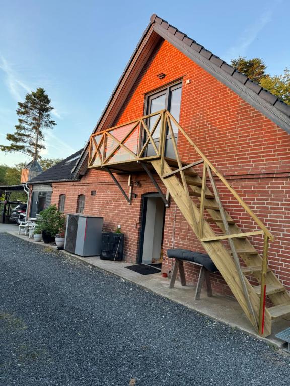 a brick house with a staircase on the side of it at Enghaven Bed & Kitchen in Ansager