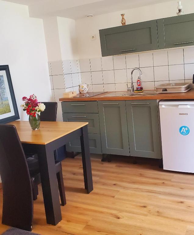 a kitchen with a table and a sink and a refrigerator at Studio Confort in Château-Chinon