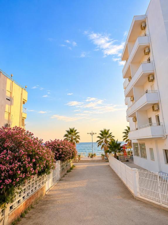 a building on the beach next to the ocean at Flors Apartments in Durrës