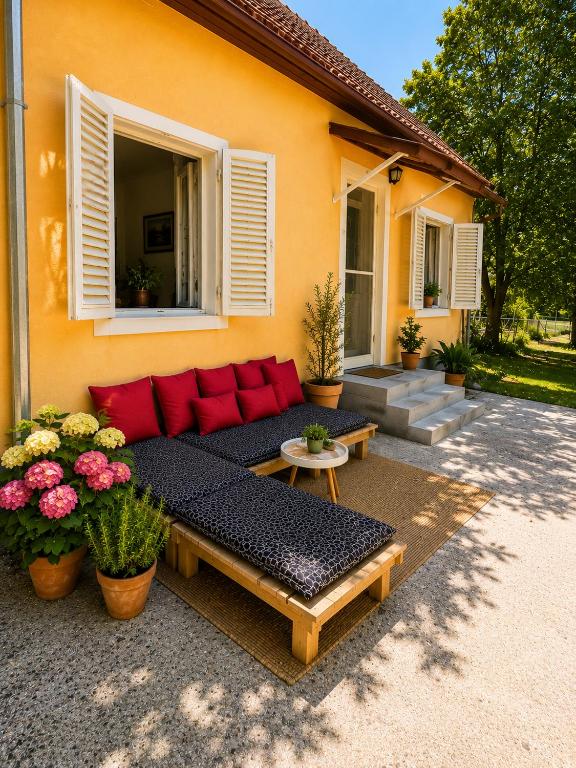 a red couch sitting outside of a house at House by the River in Orja Luka