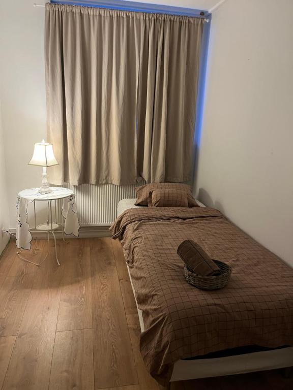 a bedroom with a bed and a table with a lamp at Quarto single in Stykkishólmur