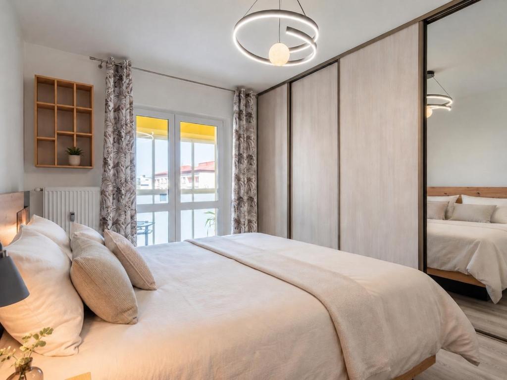 a bedroom with a large bed and a large mirror at Tatra's View Apartment in Poprad