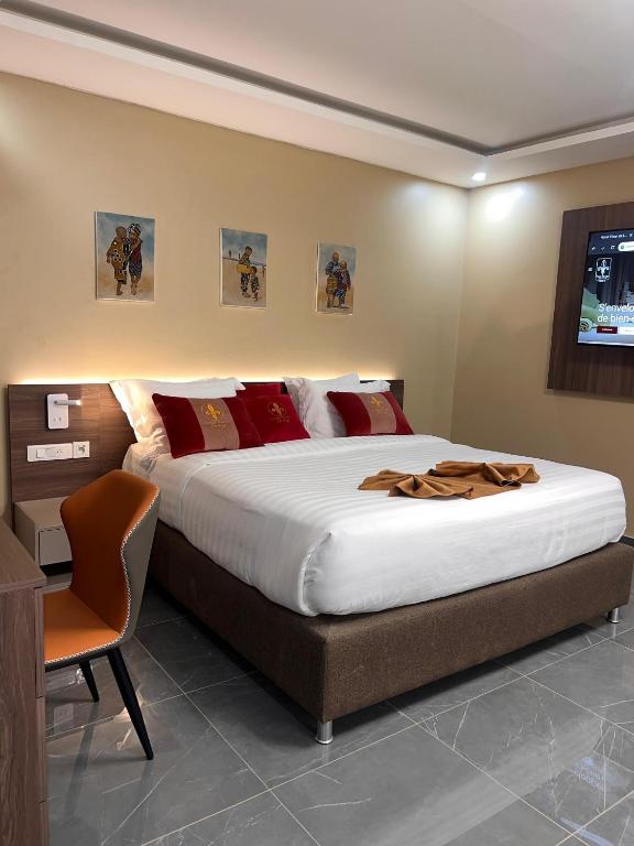 a bedroom with a large bed and a chair at Teral Hotel by Fleur de Lys in Dakar