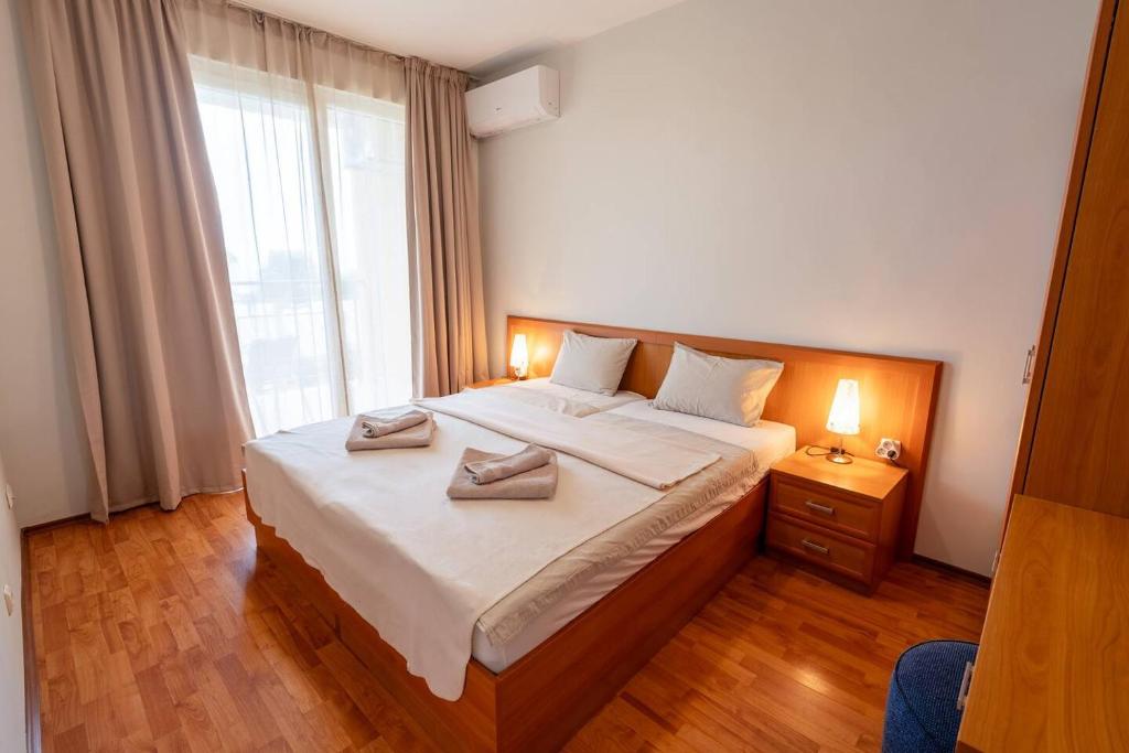 a bedroom with a large bed with two towels on it at Poolside condo in Golden Sands in Varna City