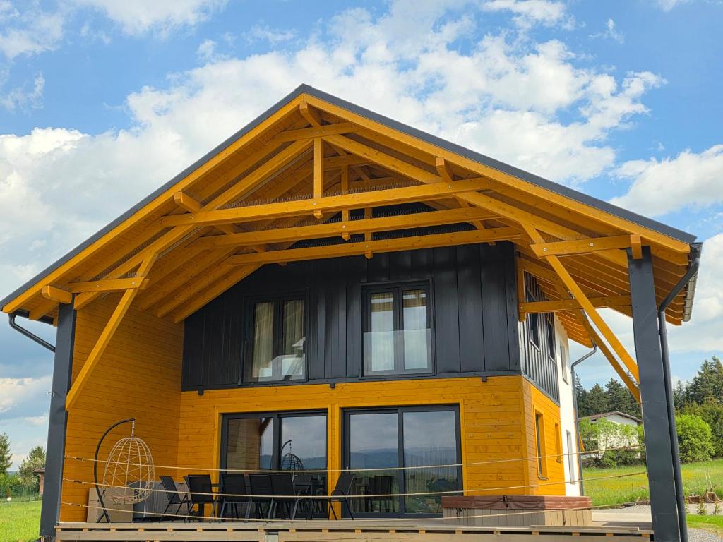 a small yellow house with a black roof at Cabana Aurora in Topliţa