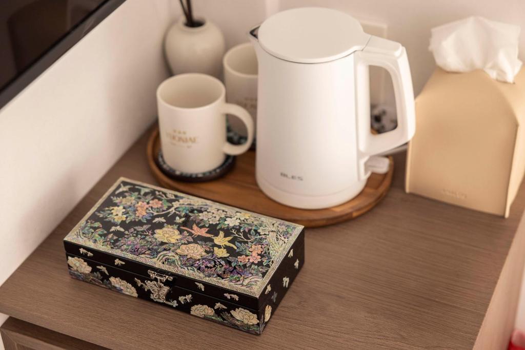 a counter with a coffee maker and two mugs on it at YUONJAE Jongno in Seoul