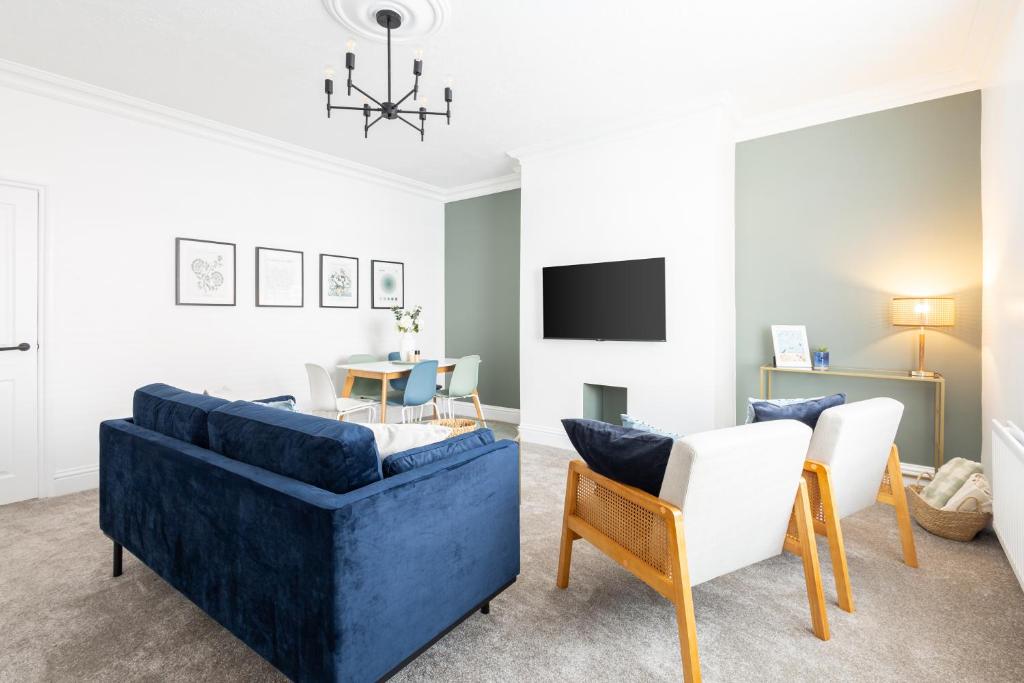 a living room with a blue couch and chairs at Spacious Beach House Near Promenade & Beach Sleeps 6 in Newbiggin-by-the-Sea