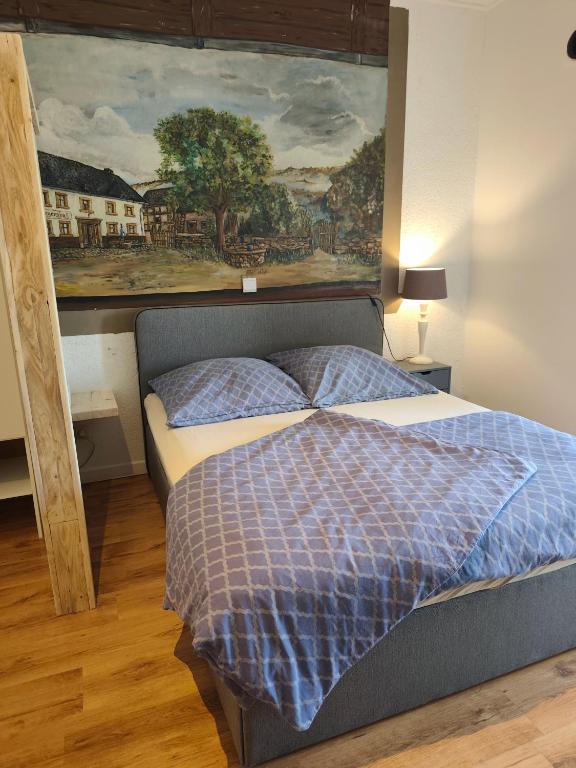 a bedroom with a bed with a painting on the wall at Apartment Linde Otzenhausen in Nonnweiler