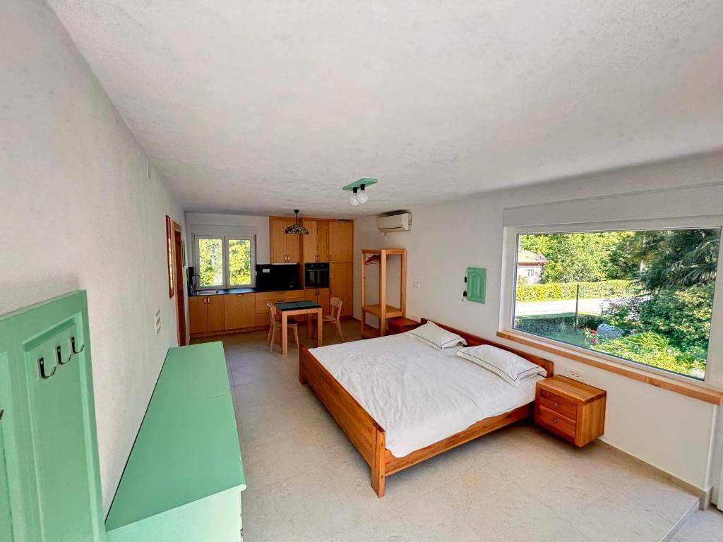 a bedroom with a bed and a large window at Apartmaji Skalabon - Milena in Kanal