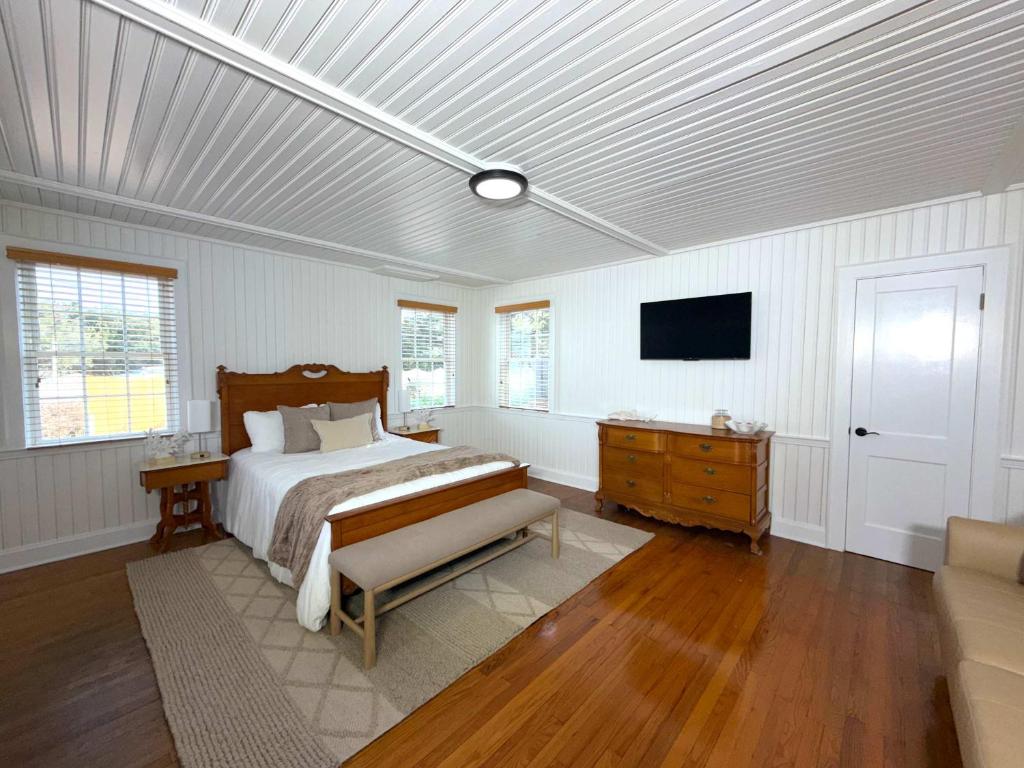 a bedroom with a bed and a television in it at 02-Sandbar Suite at The Castle Inn in Ocracoke