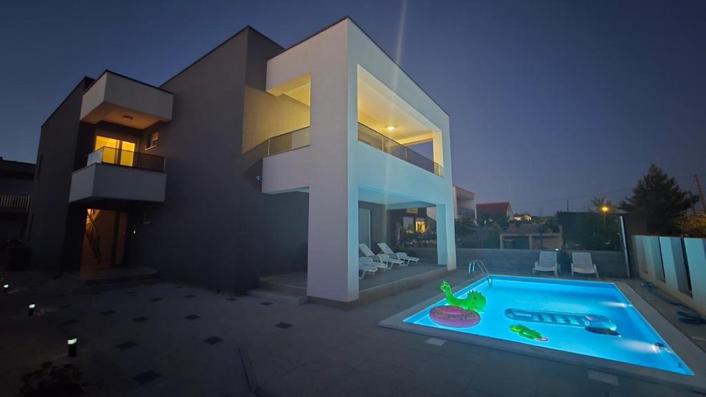 a rendering of a house with a swimming pool at night at Villa Rosa - Luxury Apartments in Vrsi