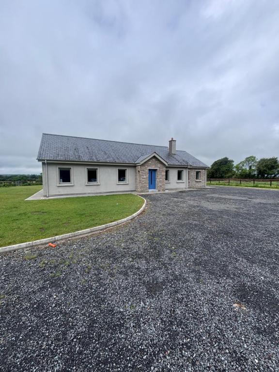 a white house with a driveway in front of it at Moate View House in Ballymore Eustace