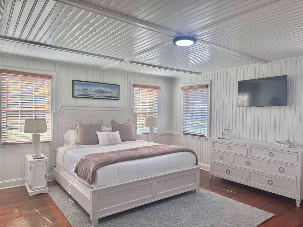 a bedroom with a bed and a flat screen tv at 04-The Seashell Suite at The Castle Inn in Ocracoke