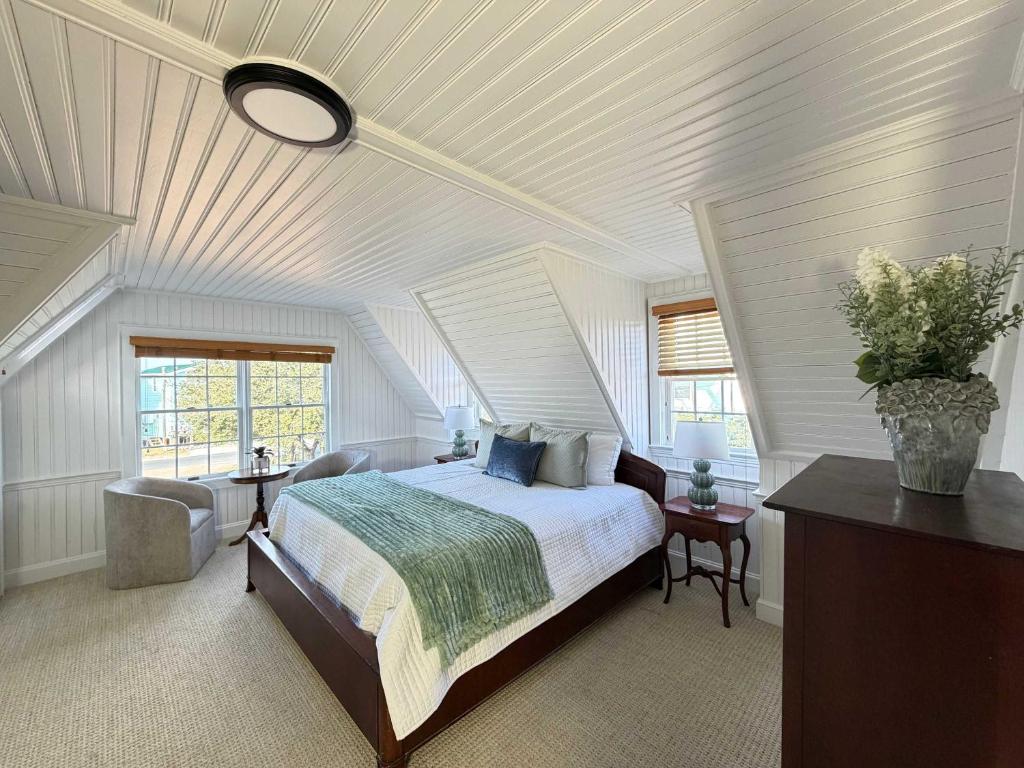 a bedroom with a large bed with a white ceiling at 06-Harbor Suite at The Castle Inn in Ocracoke