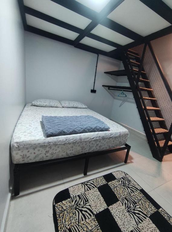 a bedroom with a bed and a staircase and a rug at Maileyna Homestay 3 in Alor Setar