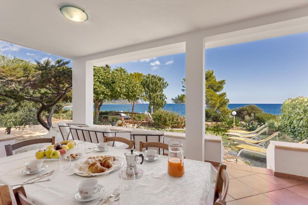 a table with food and a view of the ocean at Villa Damiano in Tertenìa