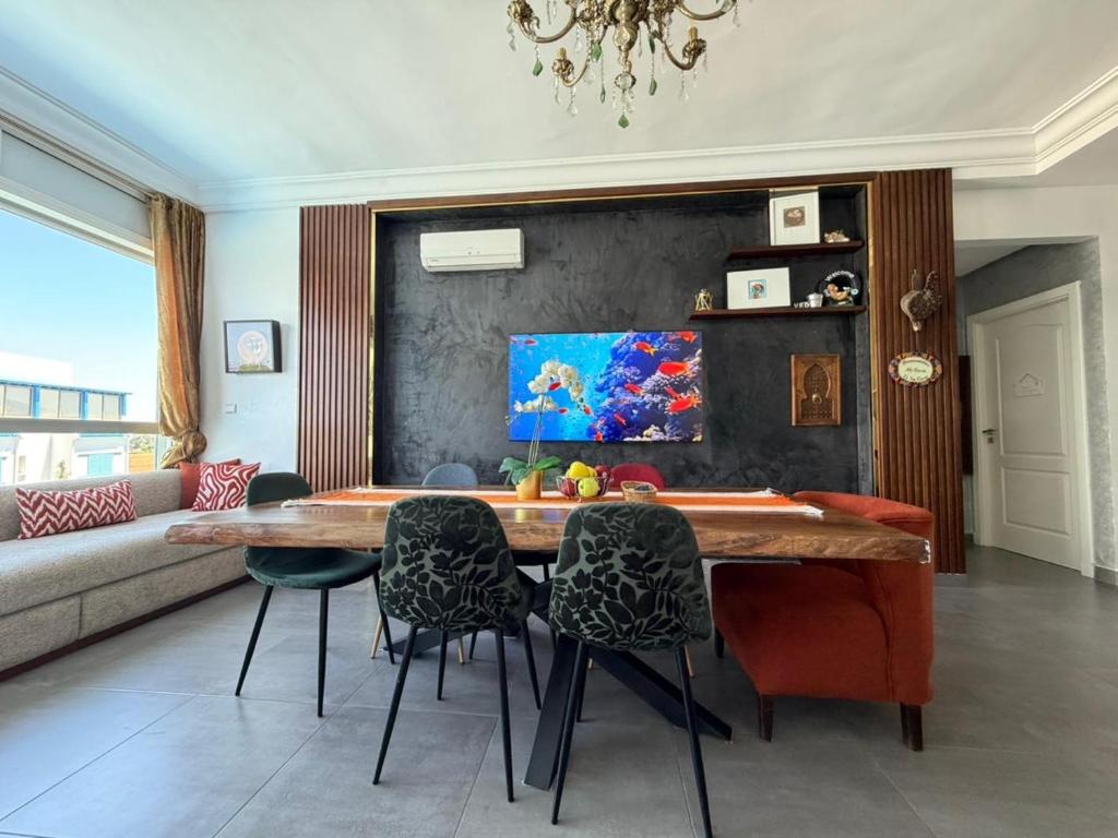 a living room with a wooden table and chairs at Appartement prestigieux à Smir Park M'diq in Marina Smir