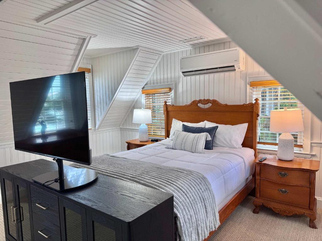 a bedroom with a bed with a flat screen tv at 07-Founders Suite at The Castle Inn in Ocracoke